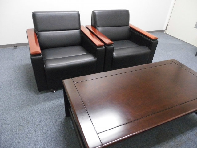 ソファとテーブルが置かれたオフィスの応接室